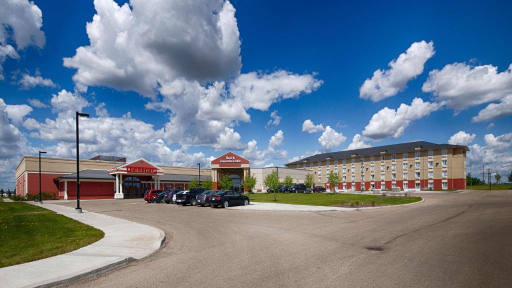 un estacionamiento con autos estacionados frente a un edificio en Camrose Resort Casino, en Camrose