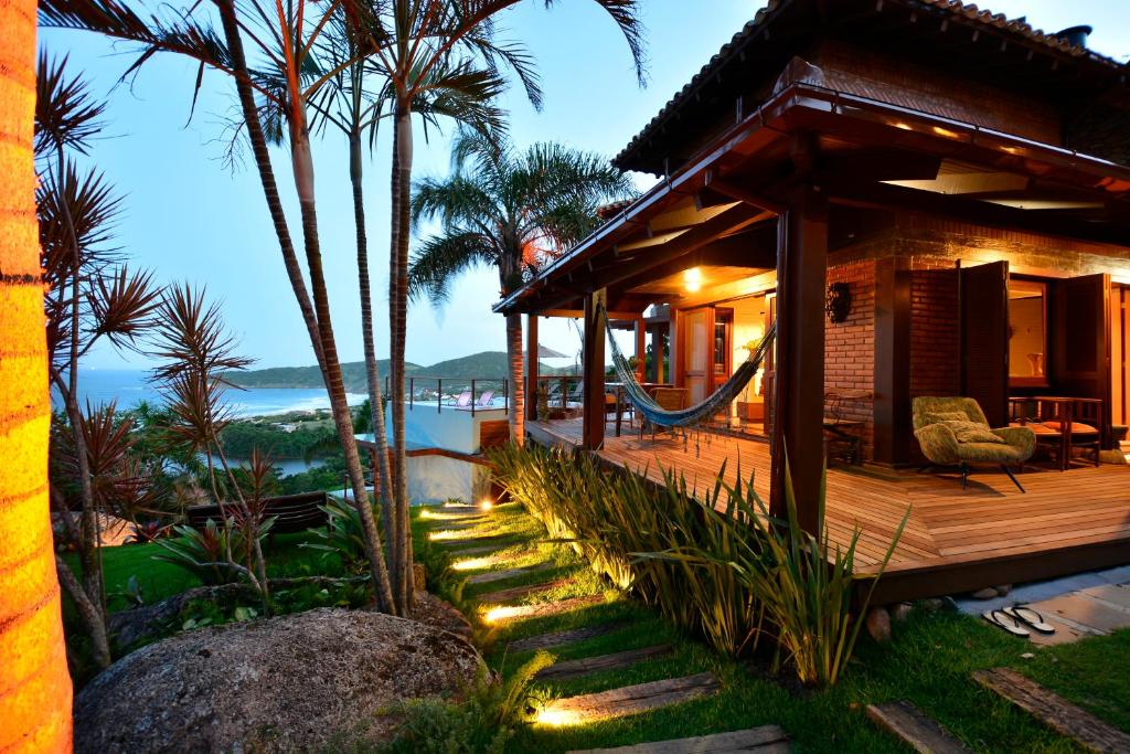 une maison avec une terrasse offrant une vue sur l'océan dans l'établissement Villa Gardena Suites, à Praia do Rosa