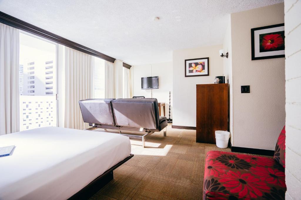 Habitación de hotel con cama y silla en Stay Hotel Waikiki en Honolulu