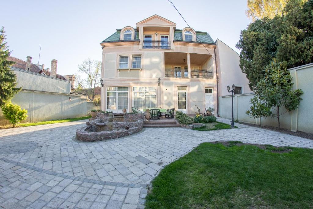 una casa grande con un patio de piedra frente a ella en Villa Ami, en Novi Sad