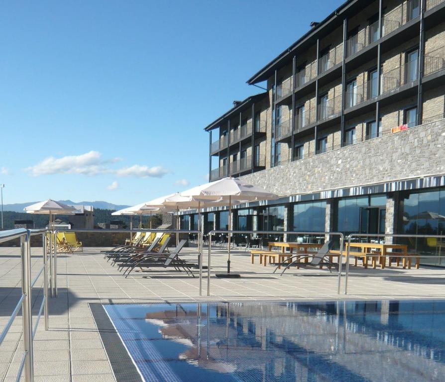 un hôtel avec des tables et des chaises et une piscine dans l'établissement HG La Molina, à La Molina