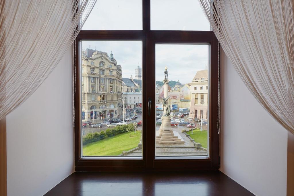 an open window with a view of a city at Apartment Mitskevycha Square 5 in Lviv