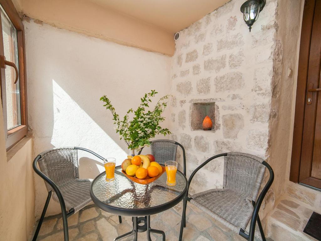 une table en verre avec des oranges dans une pièce dans l'établissement Apartments Ana, à Kotor