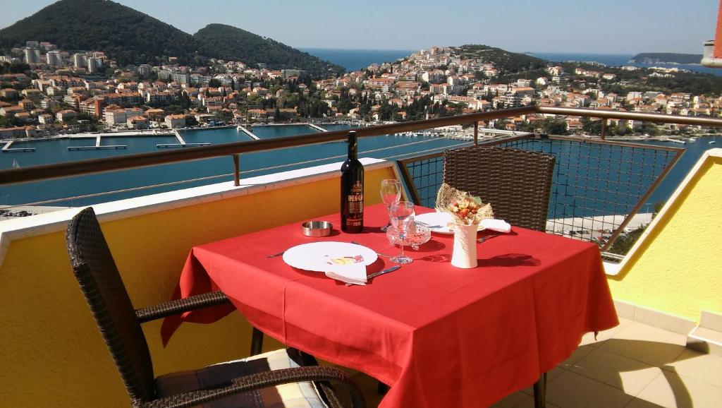 una mesa con un mantel rojo en el balcón en Apartment NikoL, en Dubrovnik