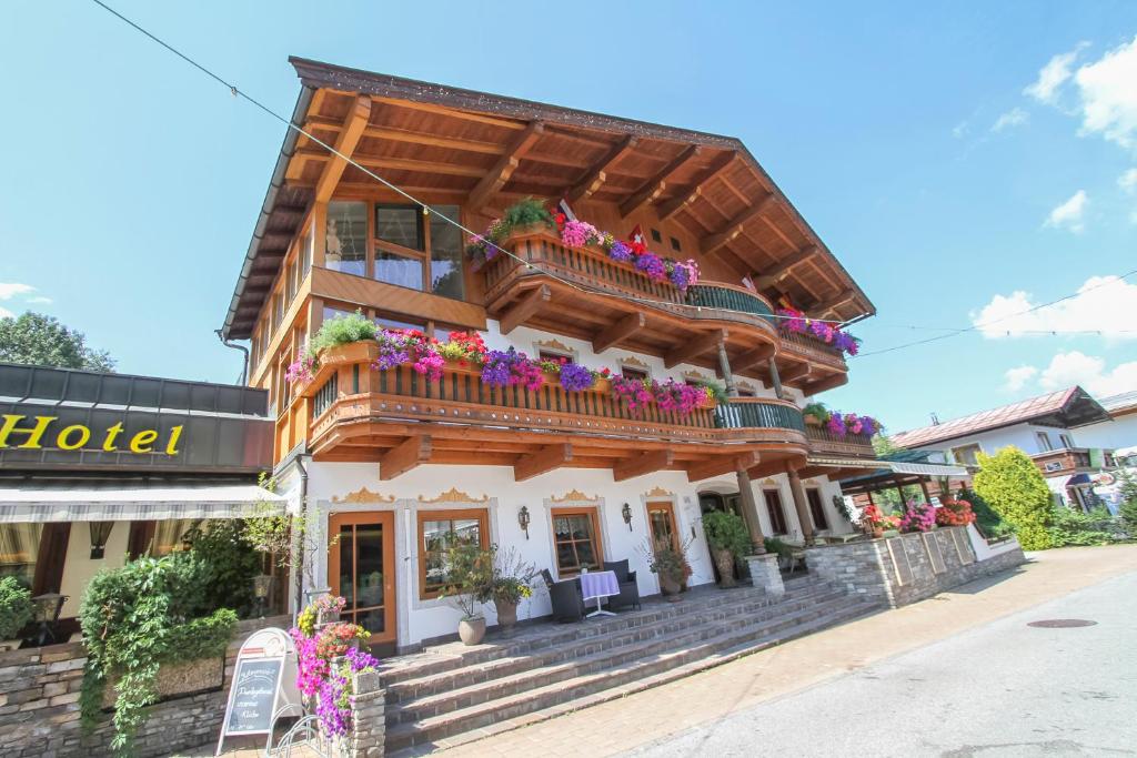 drewniany budynek z kwiatami na balkonach w obiekcie Hotel Metzgerwirt w mieście Fieberbrunn