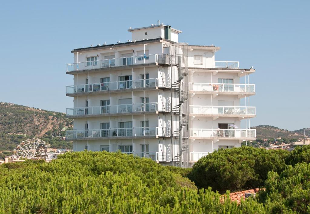 un edificio blanco alto en la cima de una colina en GoettenMar Platja d'Aro en Platja  d'Aro