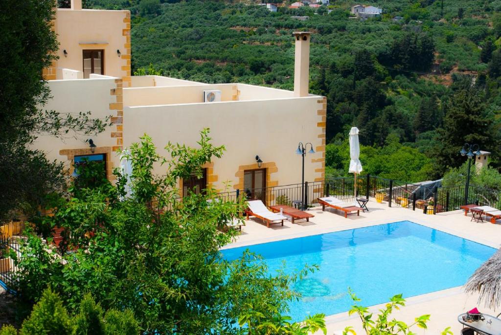 a villa with a swimming pool in front of a house at Maria Villas in Kissamos