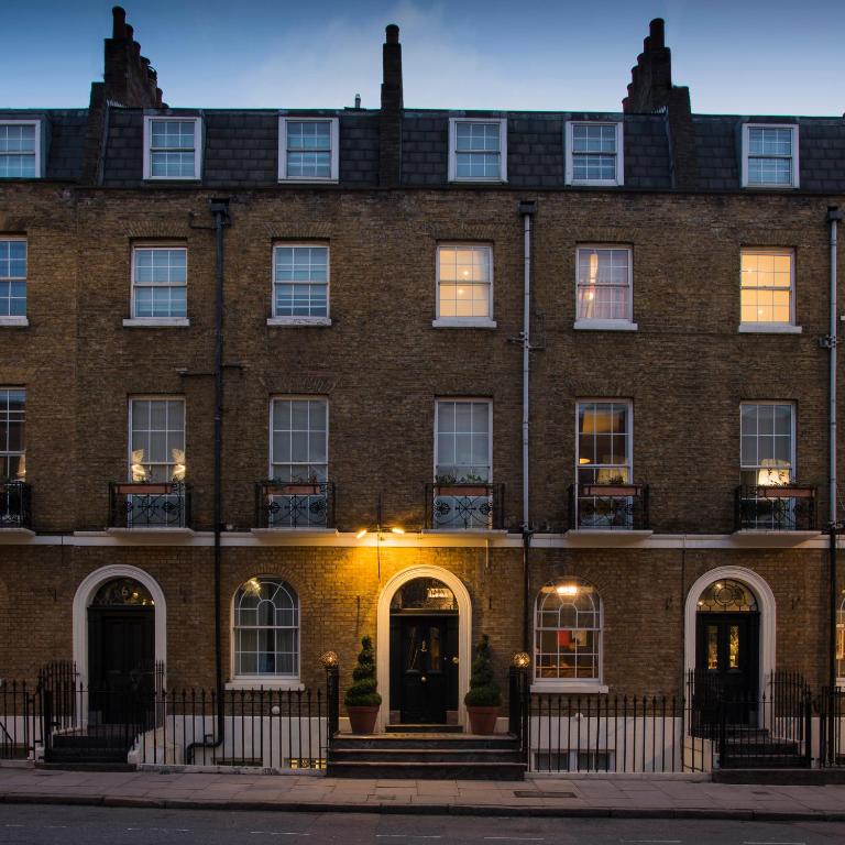 a large brick building with windows and doors at The California - London Kings Cross in London
