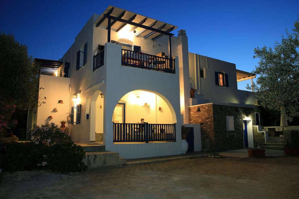 ein großes weißes Haus mit Balkon in der Nacht in der Unterkunft Aristeides - Moscha Apartments in Platis Gialos Sifnos