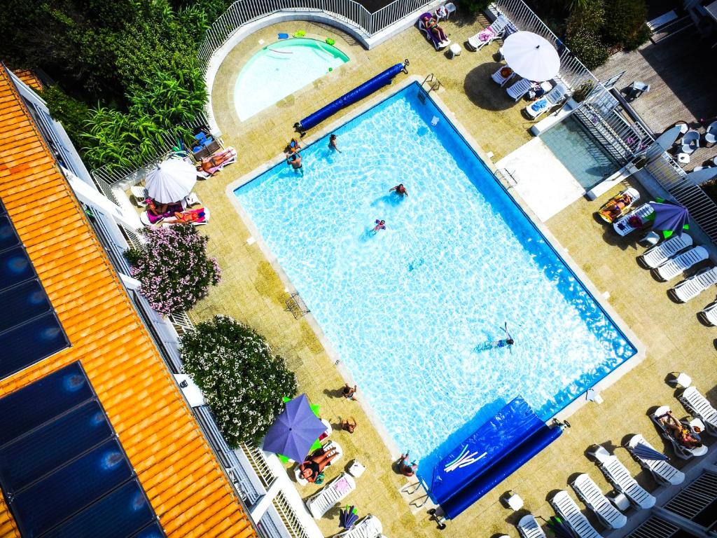 una vista sul tetto delle persone che nuotano in piscina di Village Vacances Passion Ré La Blanche a Le Bois-Plage-en-Ré
