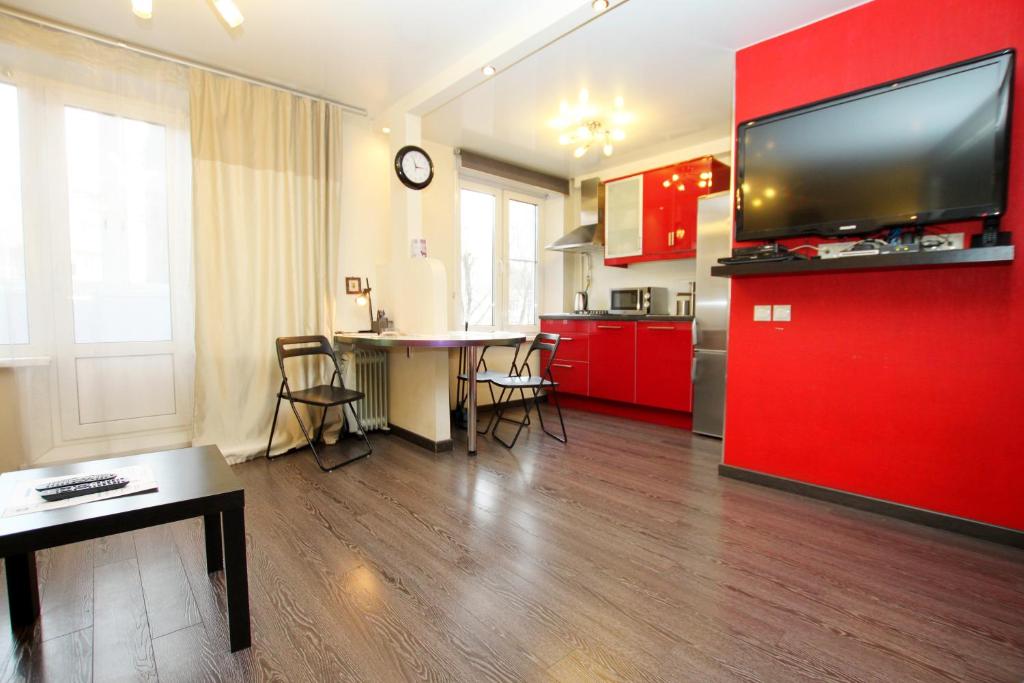 a kitchen with red cabinets and a large flat screen tv at TVST Apartments Mayakovskaya in Moscow