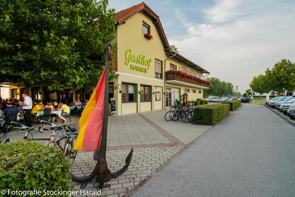 ein Gebäude mit einer Flagge davor in der Unterkunft Gasthof Kummer in Podersdorf am See
