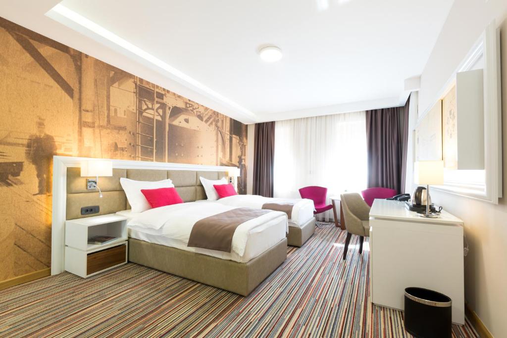 a hotel room with a bed and a desk at Hotel TESLA - Smart Stay Garni in Belgrade