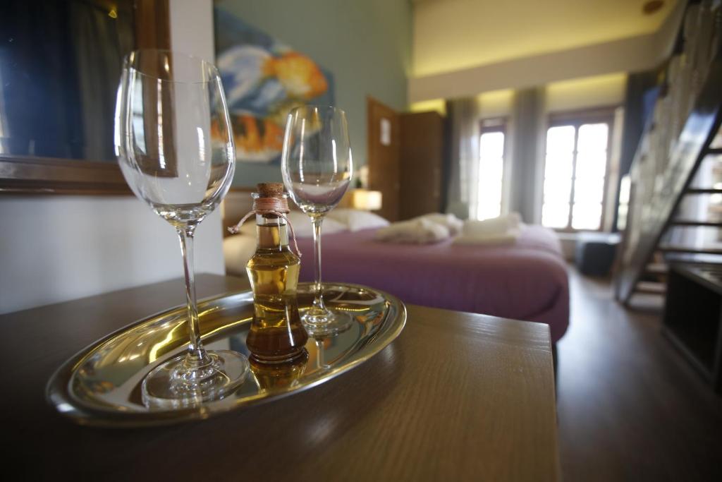two wine glasses and bottles on a tray on a table at 11City Rooms in Chania Town