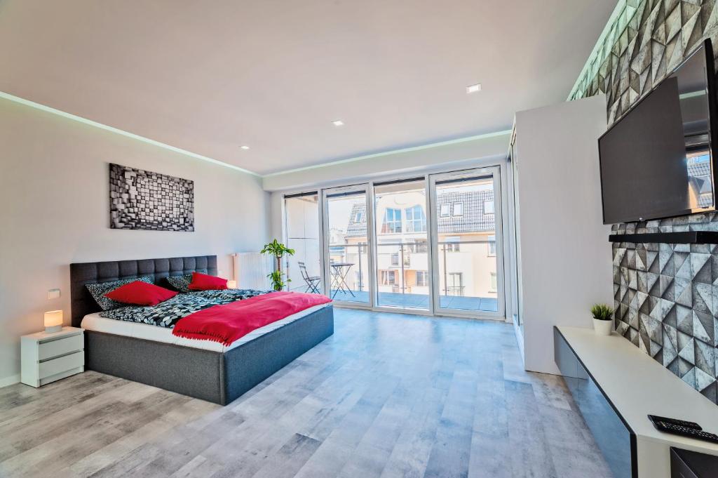 Un dormitorio con una cama con almohadas rojas. en Good Time Apartments Bóżnicza 1 & Małe Garbary 8 - Centrum Poznania, 2 min od Starego Rynku, en Poznan