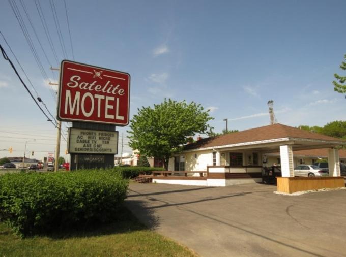 a sign for a motel in front of a building at Satelite Motel in Sault Ste. Marie