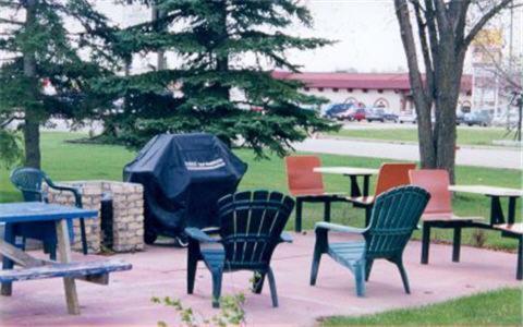 a group of chairs and picnic tables and a grill at Carravalla Inn in Melfort