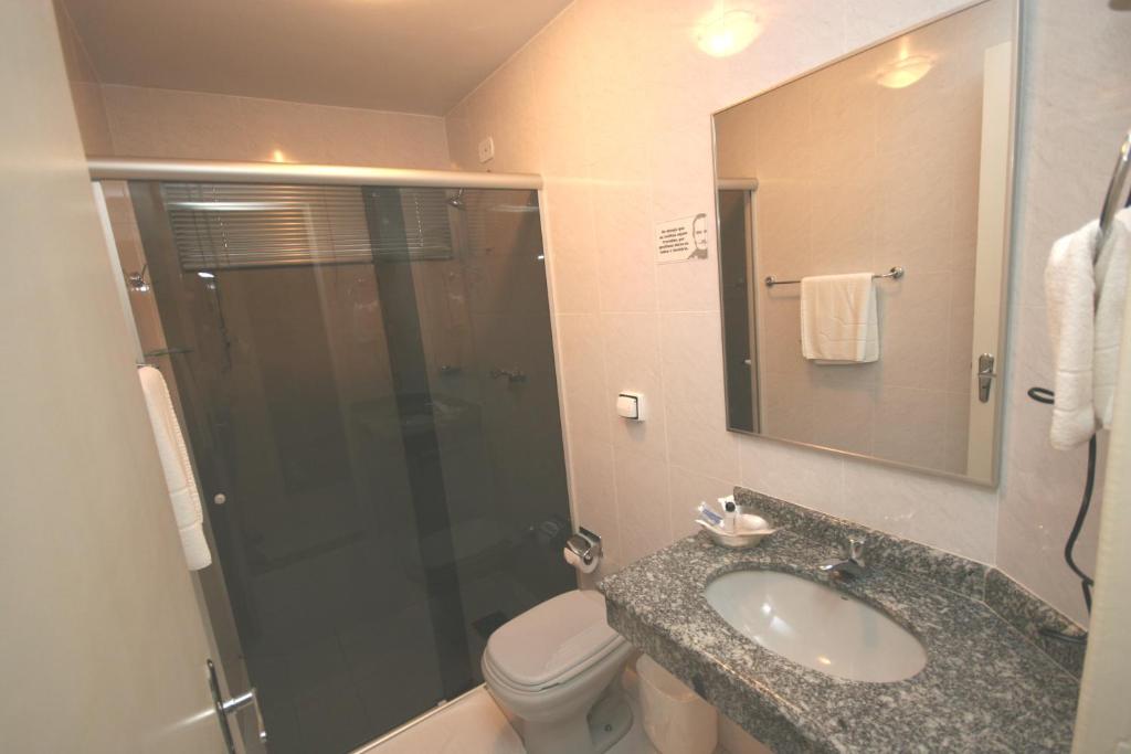 a bathroom with a toilet and a sink and a shower at Patriarca Hotel in Itapeva