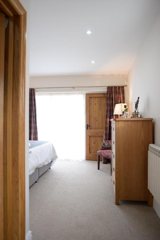 a bedroom with a bed and a large window at The Red Lion, Barn Accommodation in Thornby