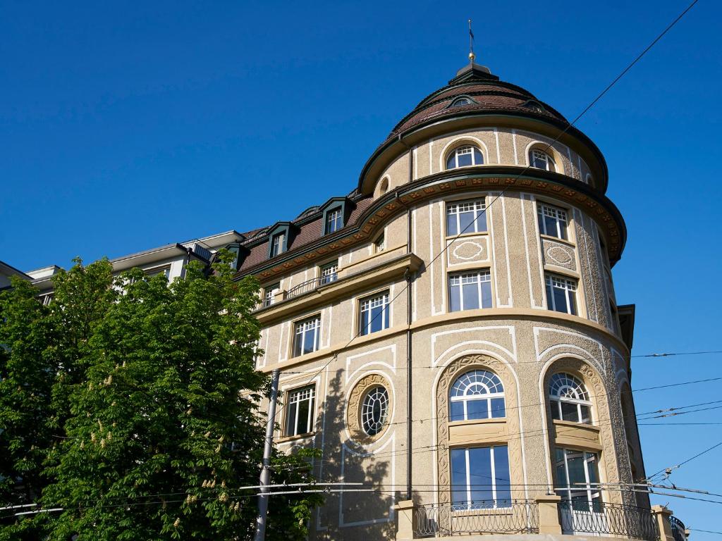 Un edificio alto con una cupola sopra di Hotel Anker Luzern a Lucerna