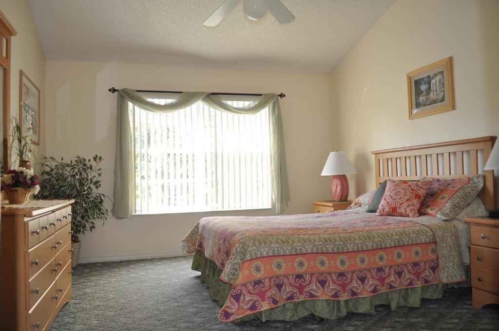 a bedroom with a bed and a window at Villas at Laguna Bay in Kissimmee