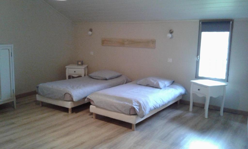 1 dormitorio con 2 camas y ventana en Au Passage des Grues, en Drosnay