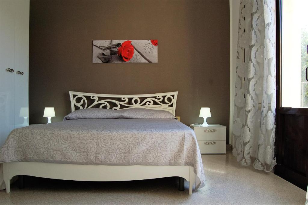 a bedroom with a bed and a red flower on the wall at Casa Rebella in Marsala
