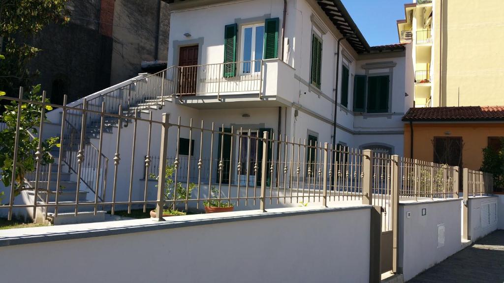 una cerca blanca frente a una casa con escaleras en La Corte di Marino, en Pisa