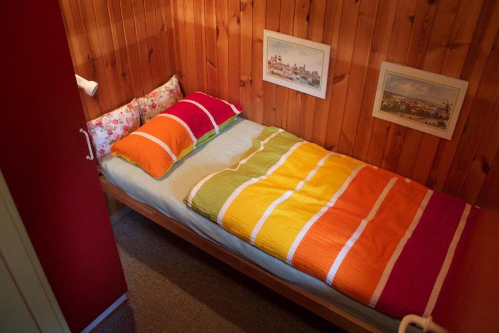 Bett mit bunter Bettwäsche und Kissen in einem Zimmer in der Unterkunft Ferienhaus Gartow in Gartow
