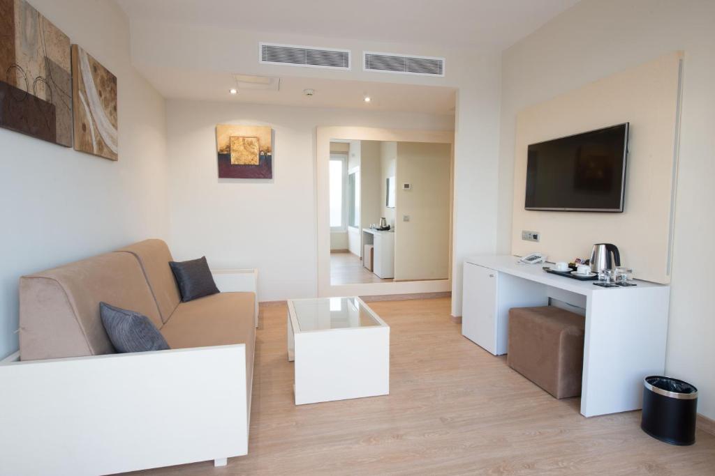 a living room with a couch and a table at HL Suitehotel Playa del Inglés - Adults Only in Playa del Ingles