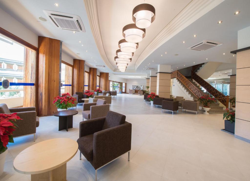 a lobby with chairs and tables and stairs at HL Suitehotel Playa del Inglés - Adults Only in Playa del Ingles