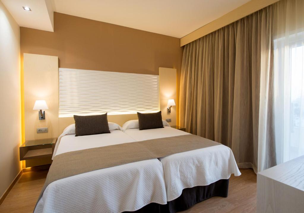 a bedroom with a large bed and a window at HL Suitehotel Playa del Inglés - Adults Only in Playa del Ingles