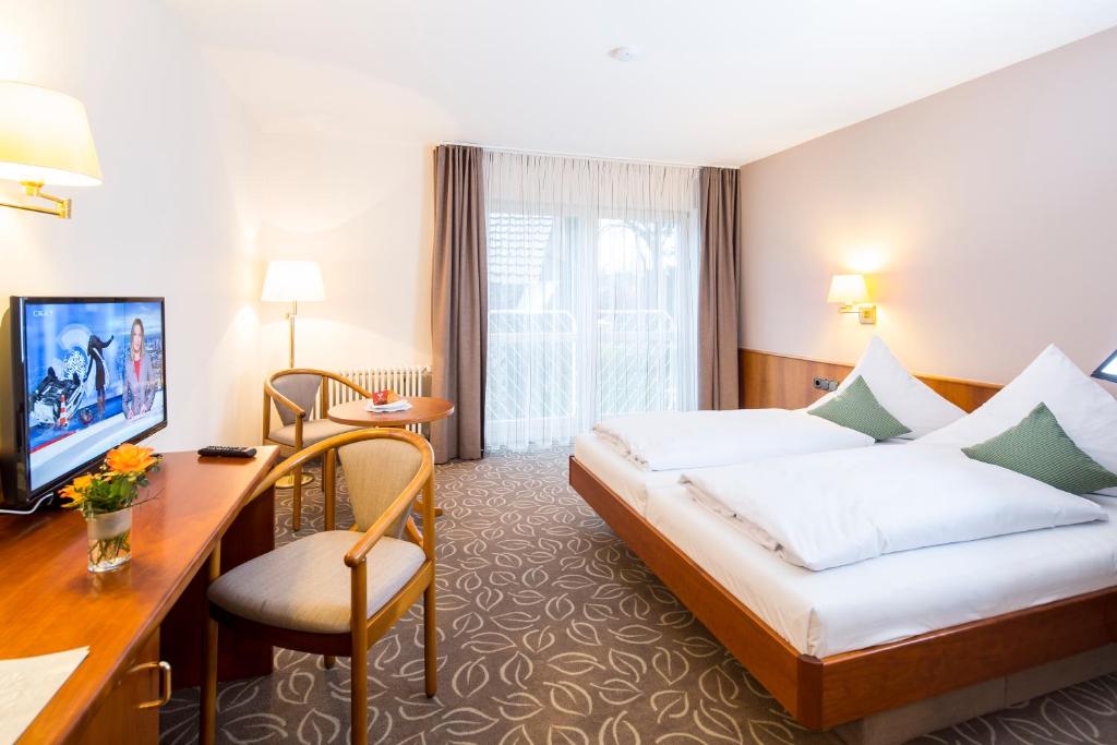 a hotel room with a bed and a desk at Hotel Gasthaus Adler in Bad Waldsee