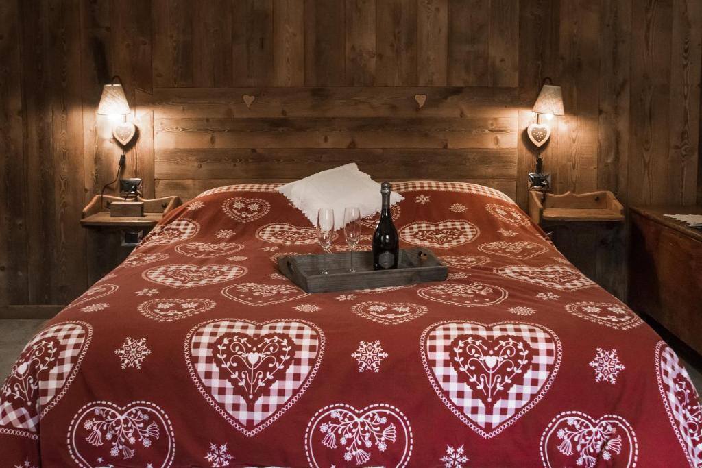 a bed with a red bedspread with hearts on it at Lo Ni di Candolle in Gignod