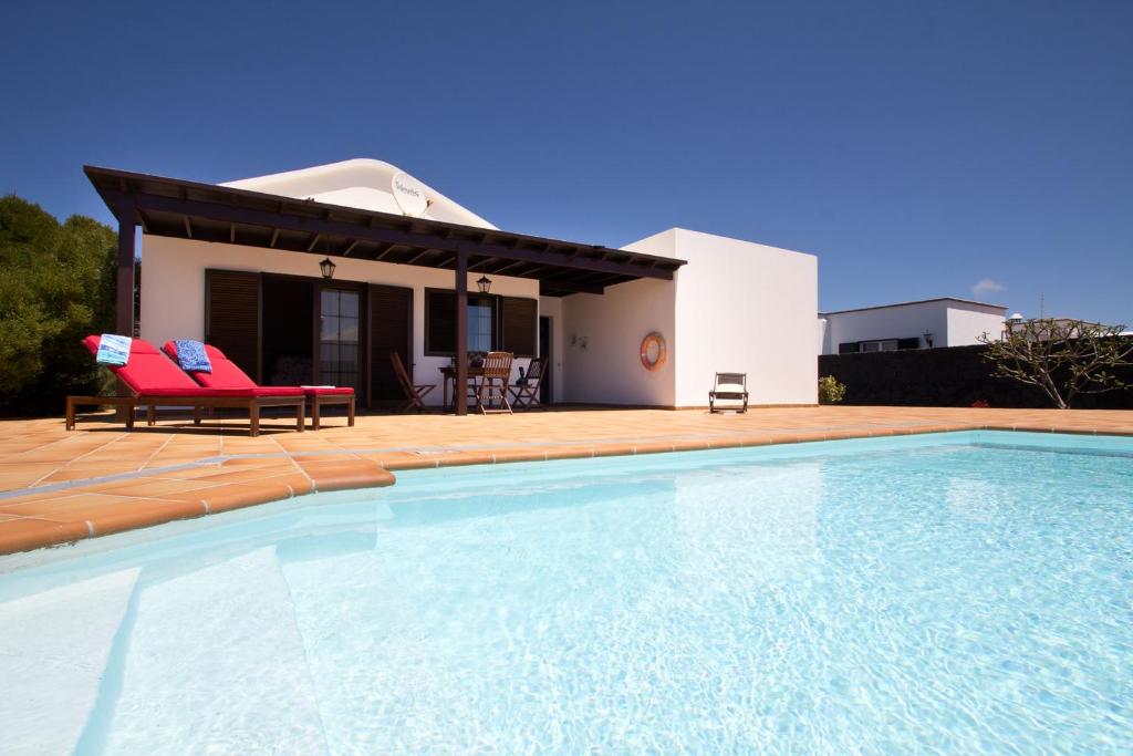 a villa with a swimming pool in front of a house at Holiday Villa Campesina with Private Pool in San Bartolomé