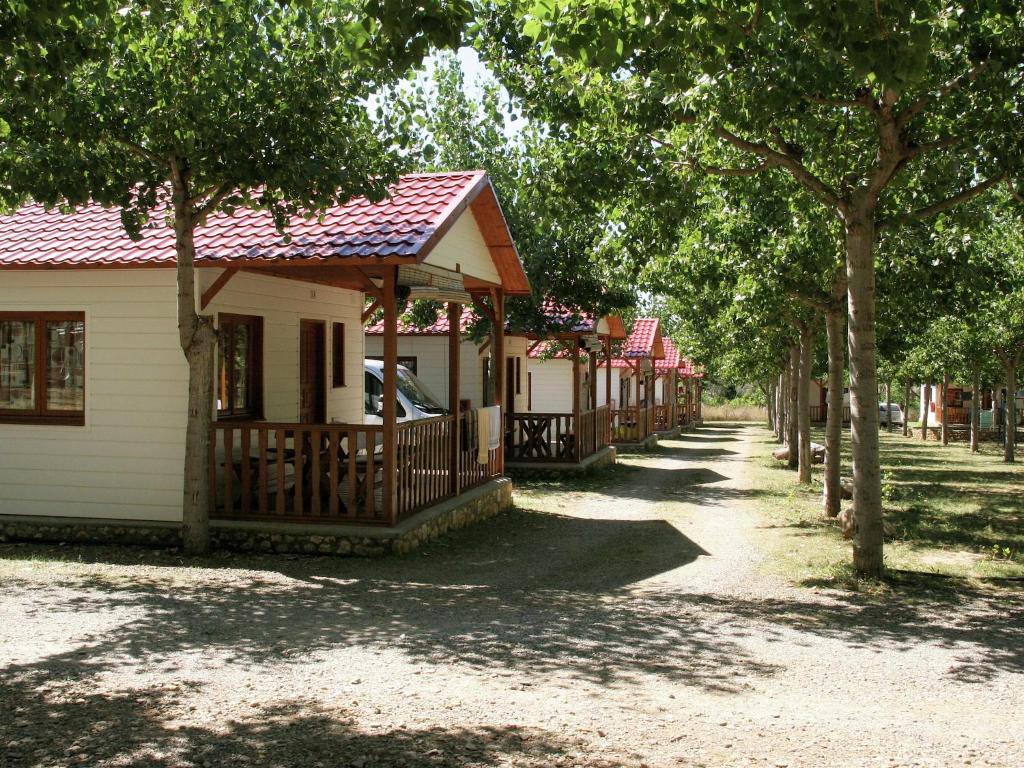 una fila de casas en una calle con árboles en Holiday home Vakantiepark Isábena 6, en La Puebla de Roda