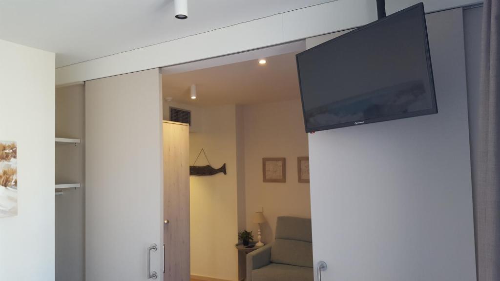 Televízia a/alebo spoločenská miestnosť v ubytovaní Hotel L'Escala Centre