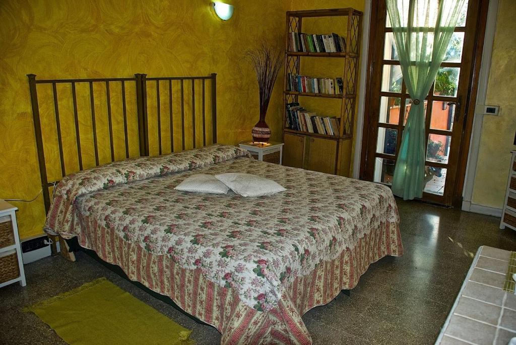 B&B Mery Lho في أبريليا: غرفة نوم مع سرير ورف كتاب