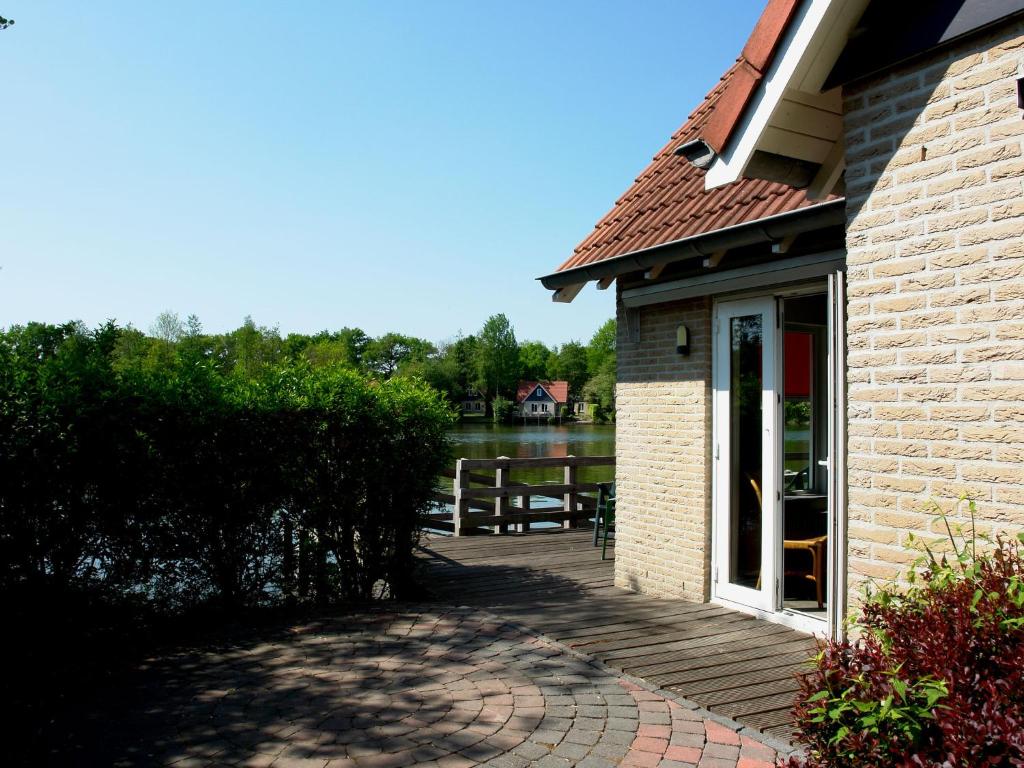 een gebouw met een terras naast een waterlichaam bij Holiday home Vakantiepark Het Timmerholt 5 in Westerbork