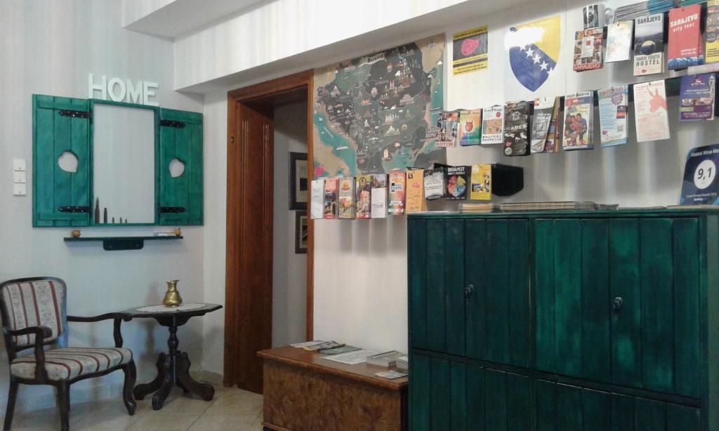 Habitación con armario verde, silla y mesa. en Hostel Nina Mostar, en Mostar
