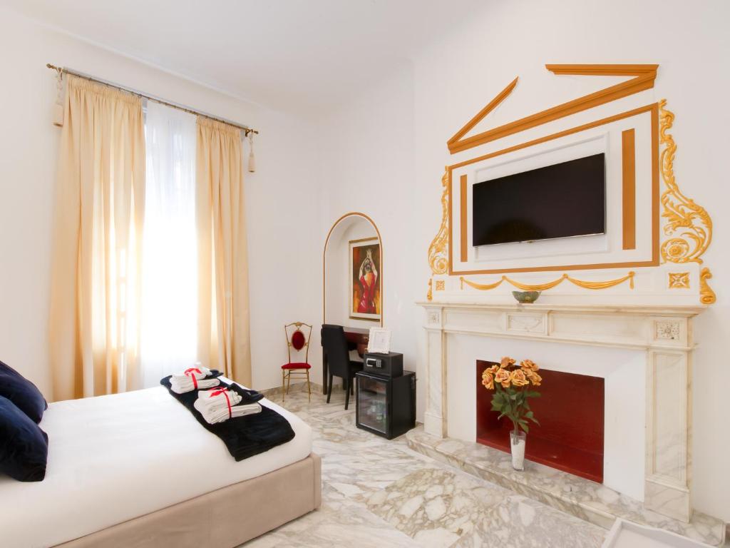 a bedroom with a bed and a fireplace with a tv above it at Queen Palace Suites in Rome