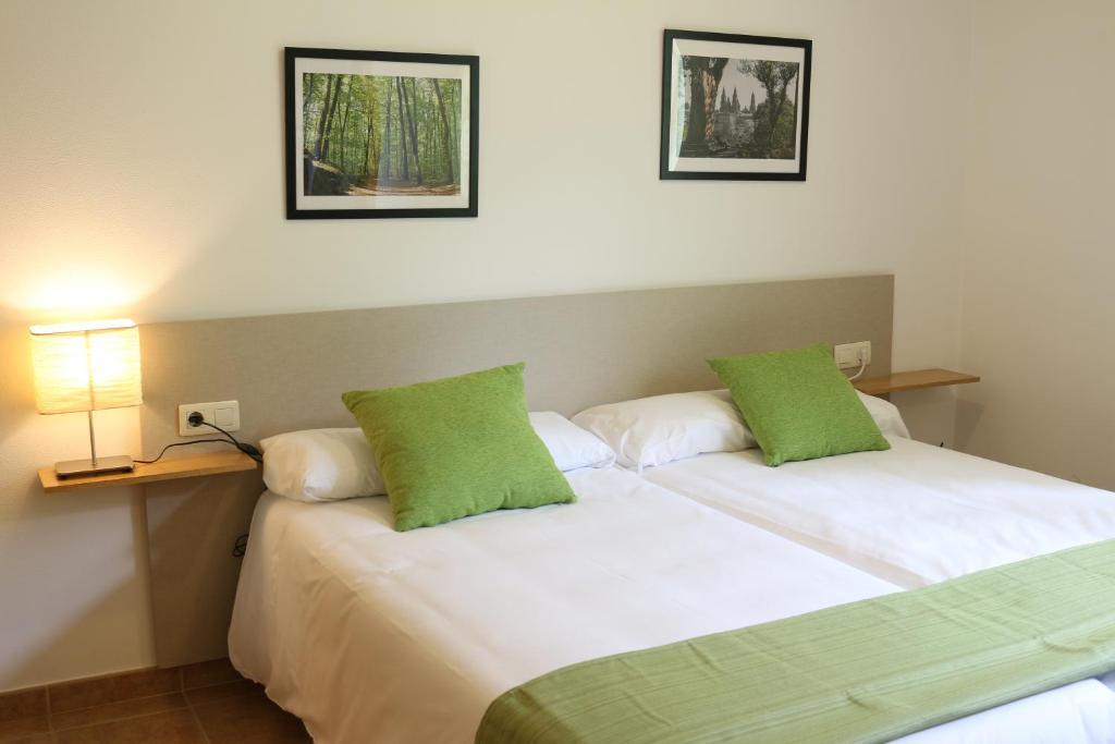 サンティアゴ・デ・コンポステーラにあるApartamentos Turísticos Cancelas by Bossh Hotelsのベッド2台が隣同士に設置された部屋です。