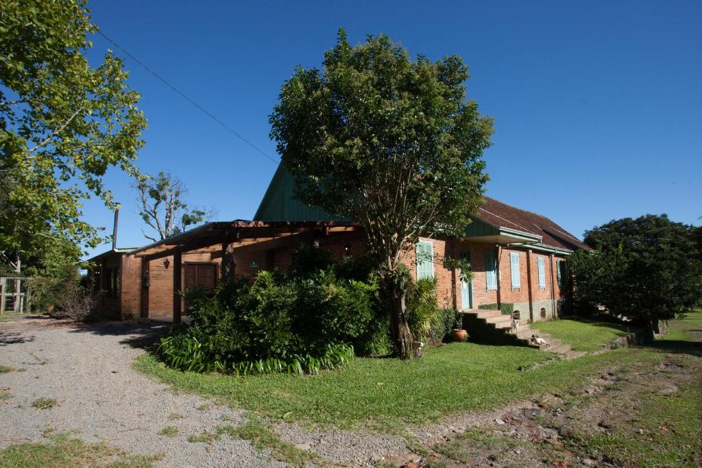 a brick house with a tree in front of it at Casa Blauth in Farroupilha