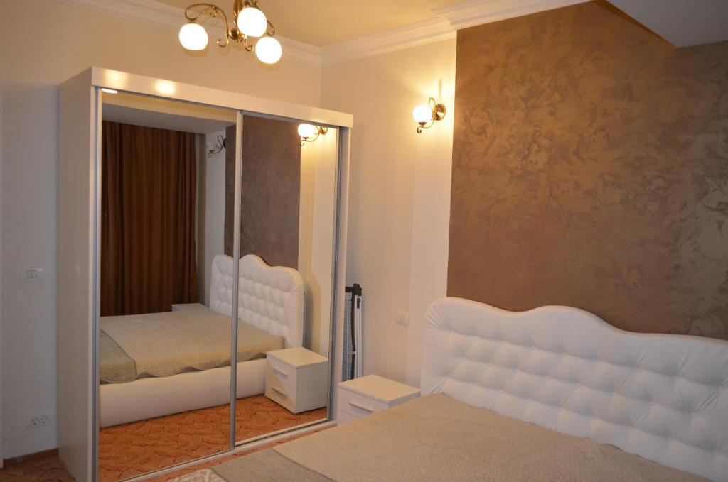 ママイア・ノルドにあるApartament Casyana - Mamaia Nordのベッドルーム(鏡、ベッド付)