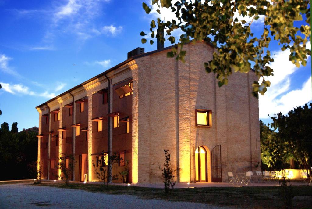 ein großes Backsteingebäude mit eingeschaltetem Licht in der Unterkunft Principessa Pio in Ferrara
