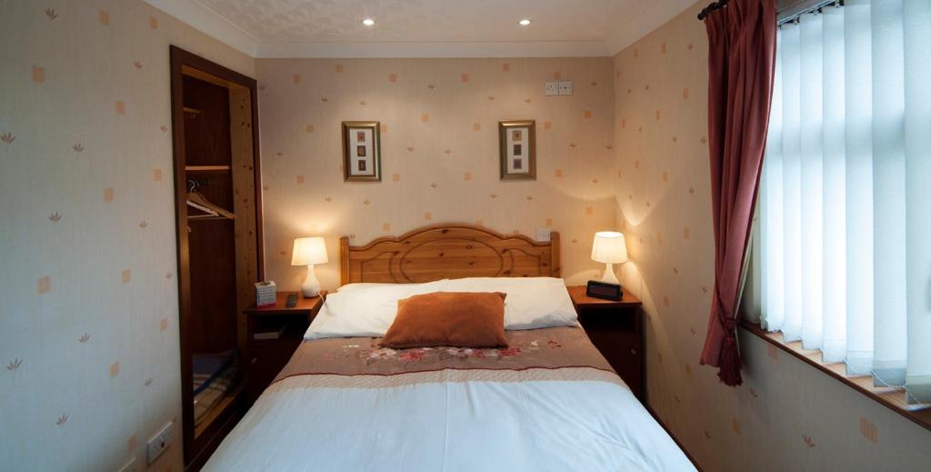 um quarto com uma cama com uma almofada castanha em Browns Country House em Bushmills