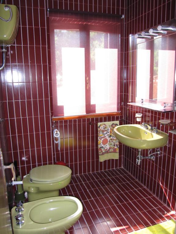a bathroom with a green toilet and a sink at La Casa di Rosa in Ioppolo