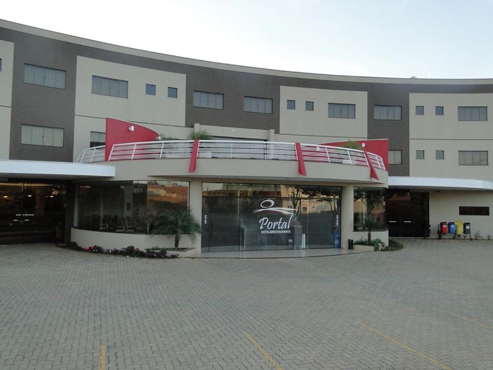 un gran edificio con balcón en un aparcamiento en Hotel Portal en Carlópolis