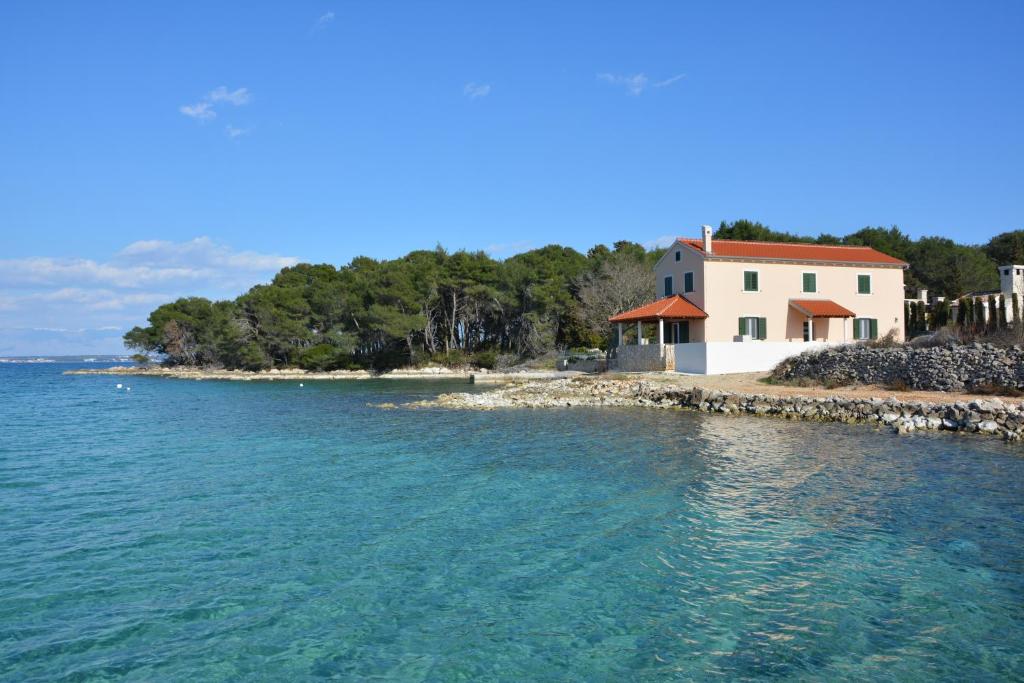 una casa en la orilla de un cuerpo de agua en Holiday home Kucerina en Ugljan