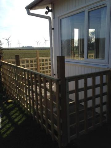 a porch of a house with a fence and a window at For-Get-Me-Not Chalet semi detached in Bridlington